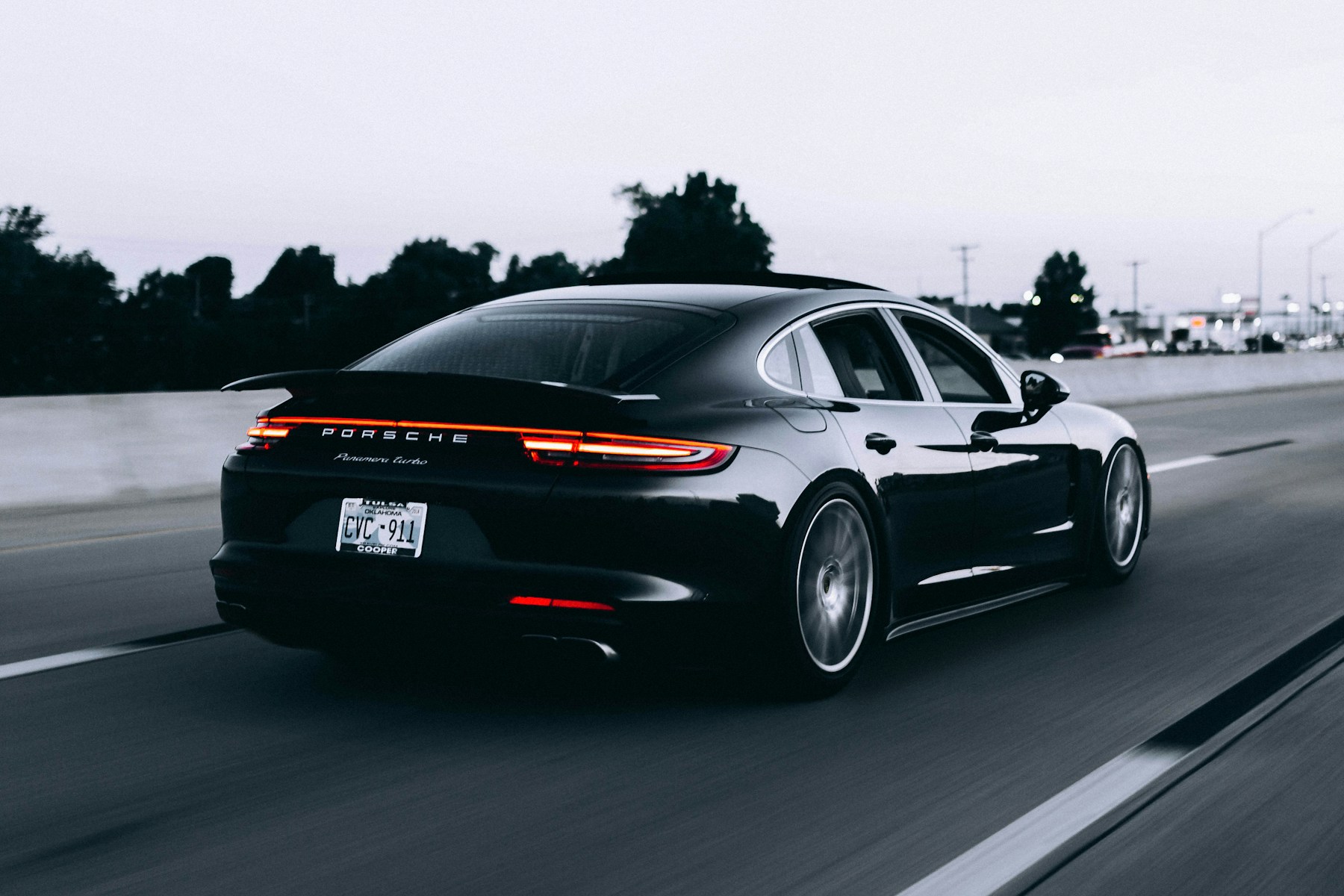 Dark Porsche Panamera driving along an open road